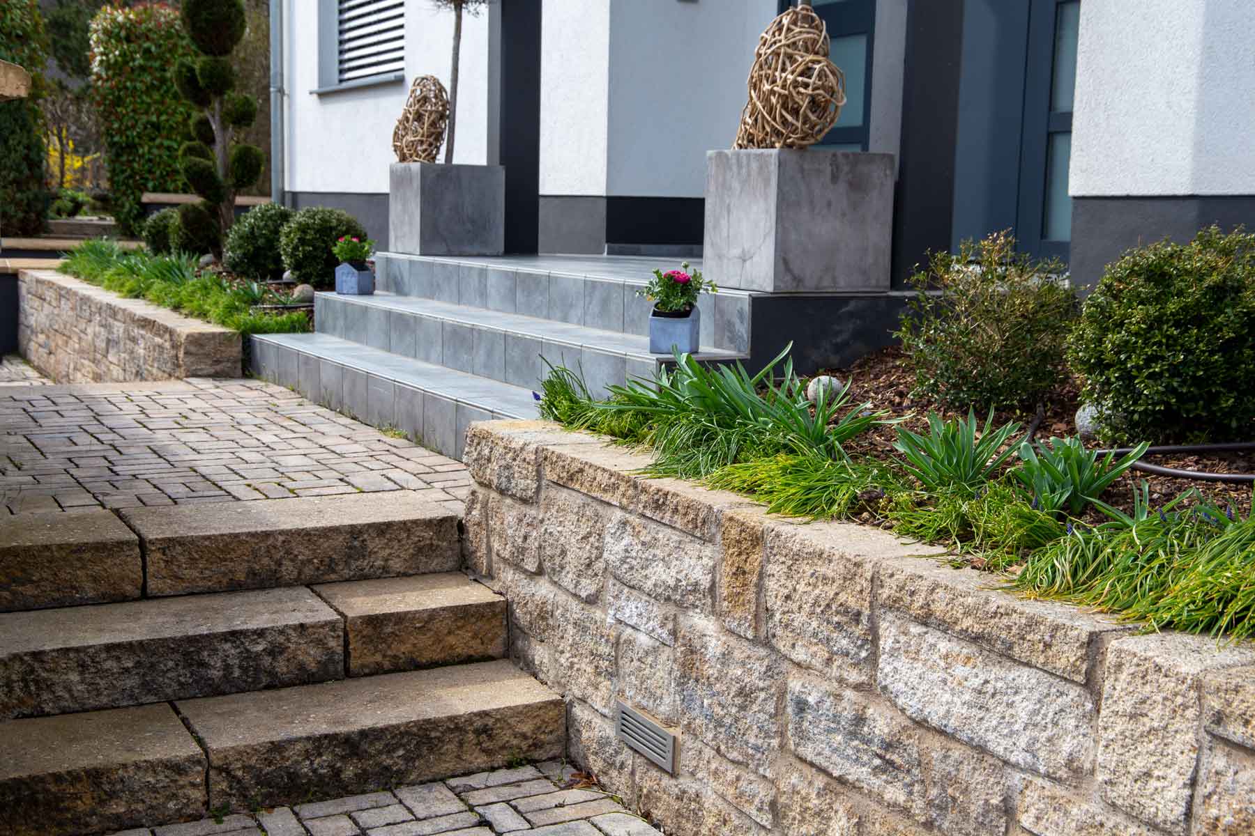 Moderne Treppe mit Steinmauern und Pflanzen