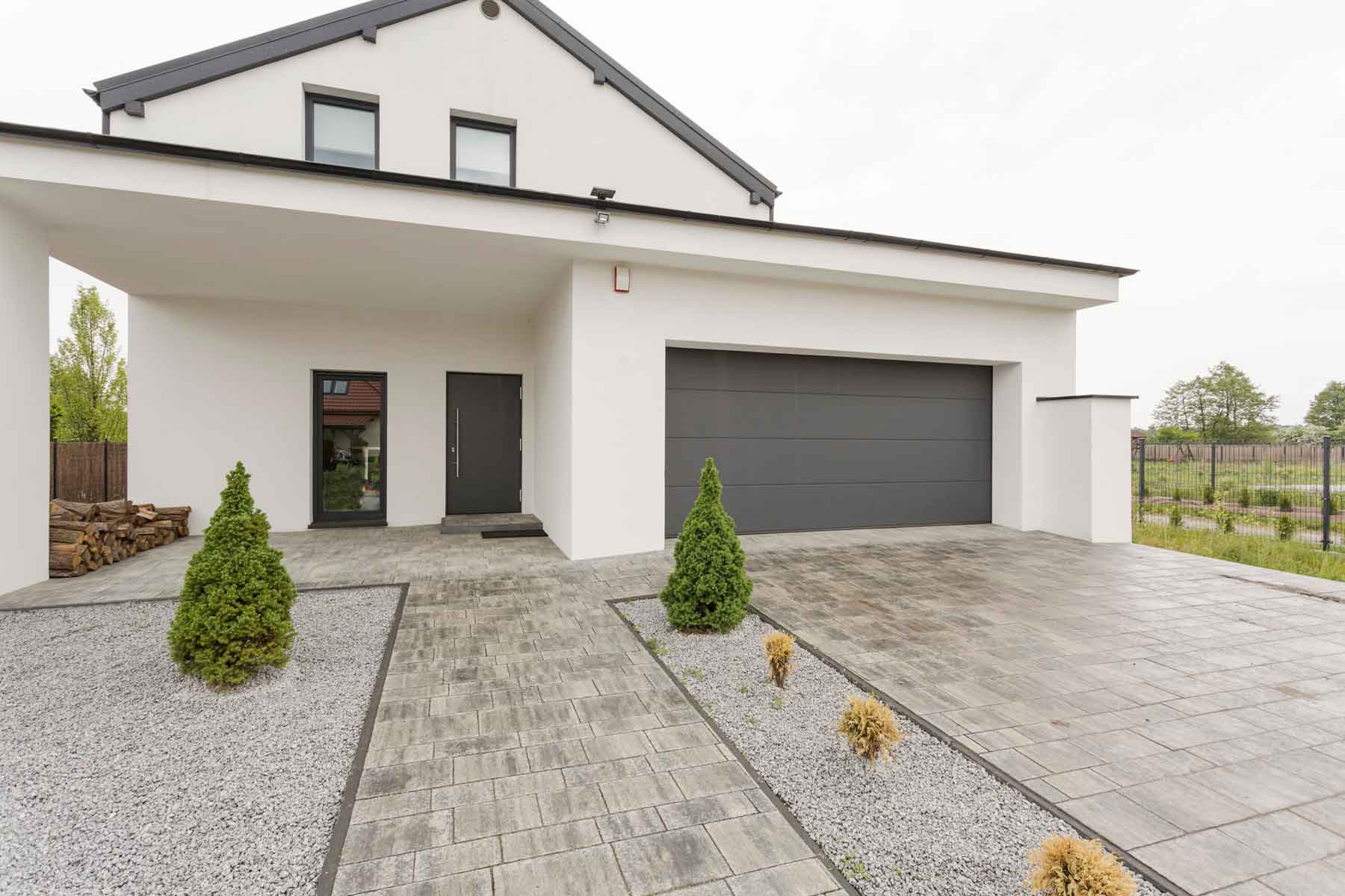 Moderne Einfahrt mit Garage und Pflanzen